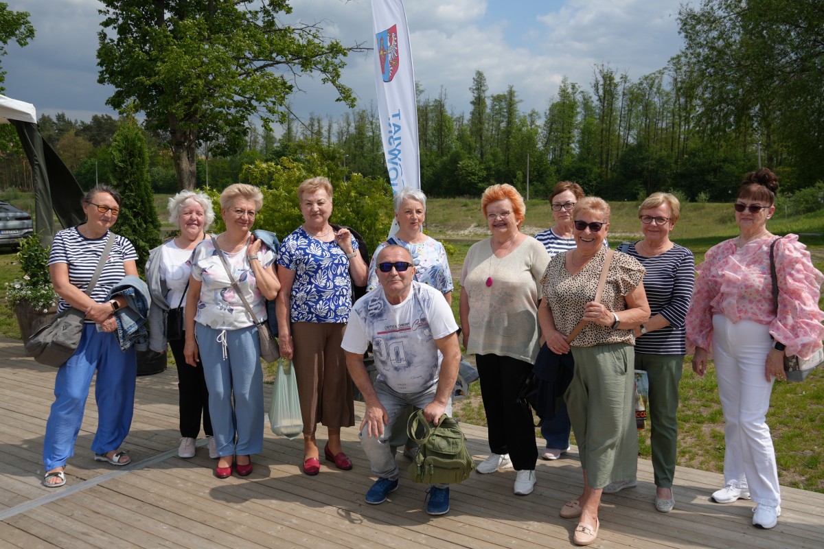 Zdjęcie kulunastu seniorów stojących obok siebie do wspólnego zdjęcia.