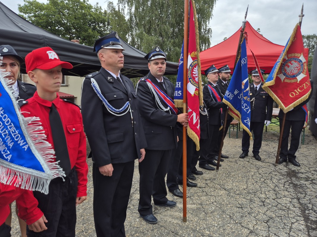 Strażacy stoją na placu przed remizą 
