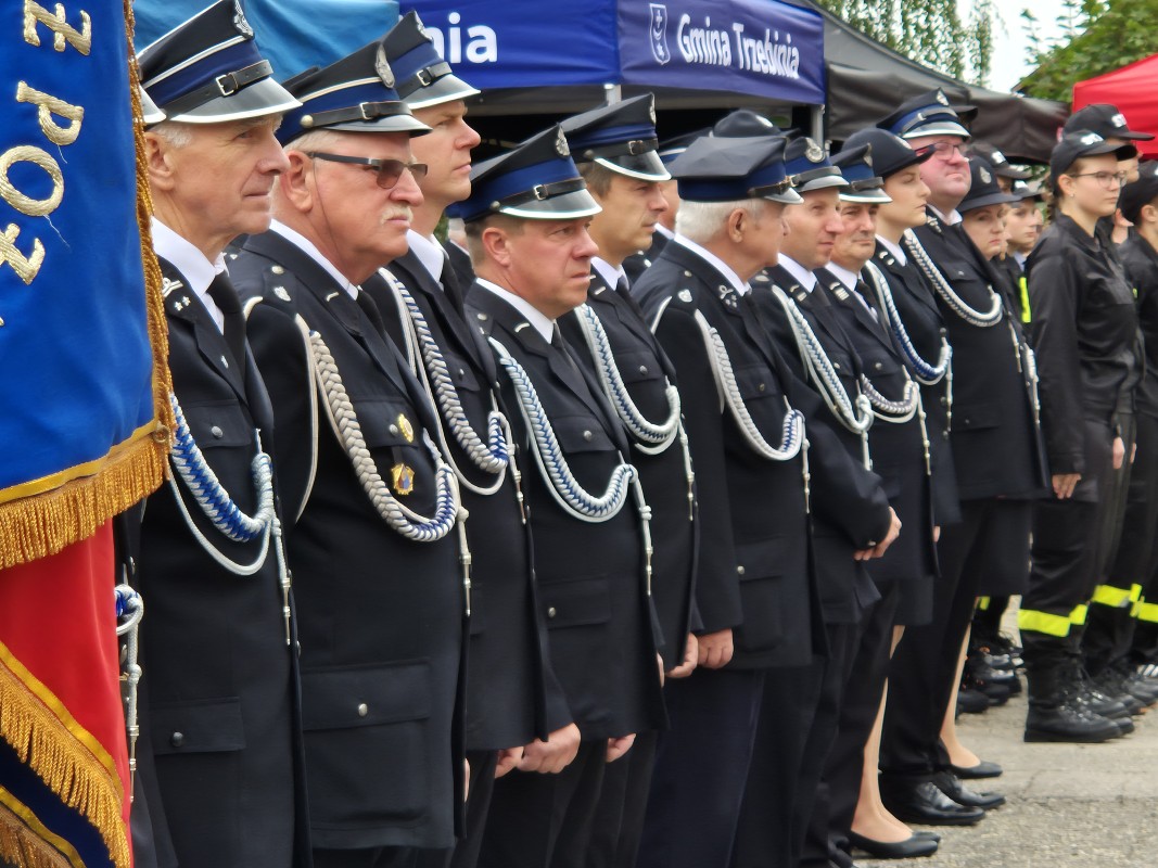 Strażacy stoją na placu przed remizą 
