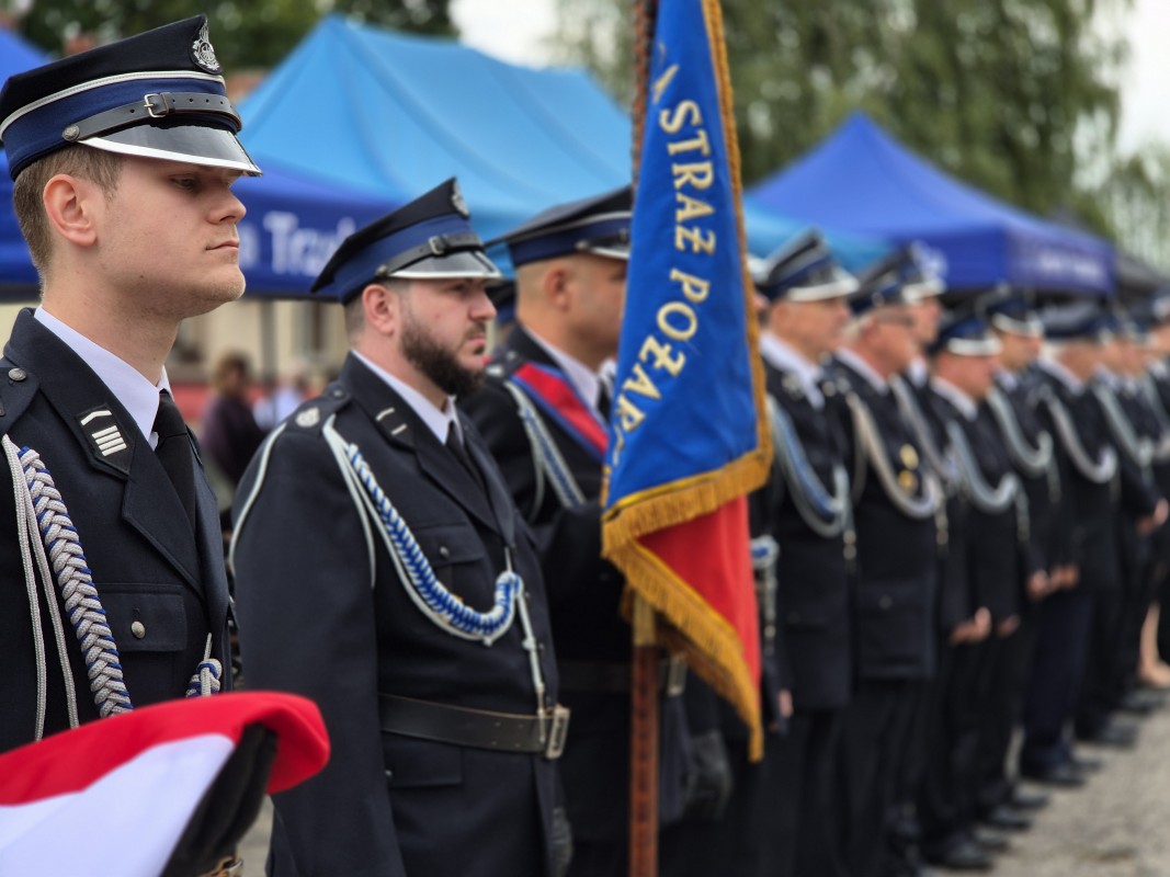 Strażacy stoją na placu przed remizą 
