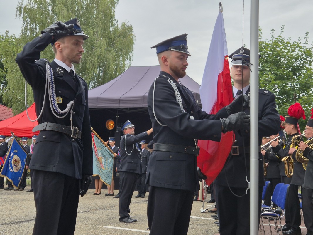 Strażacy stoją na placu przed remizą 