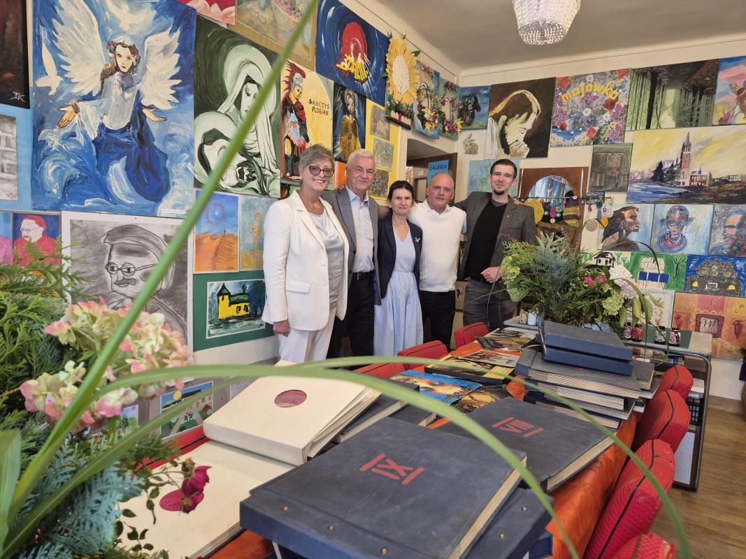 W galerii artystycznej kilka osób ogląda obrazy
