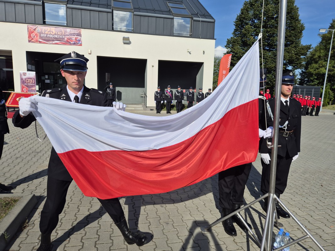 Strażacy wciągają flagę na maszt