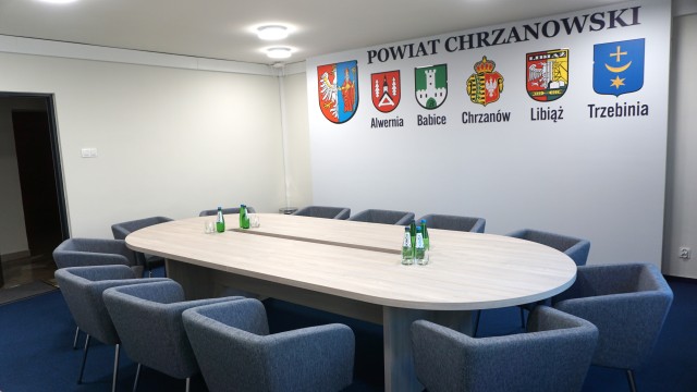 Pomieszczenie biurowe, na ścianie 6 herbów JST 