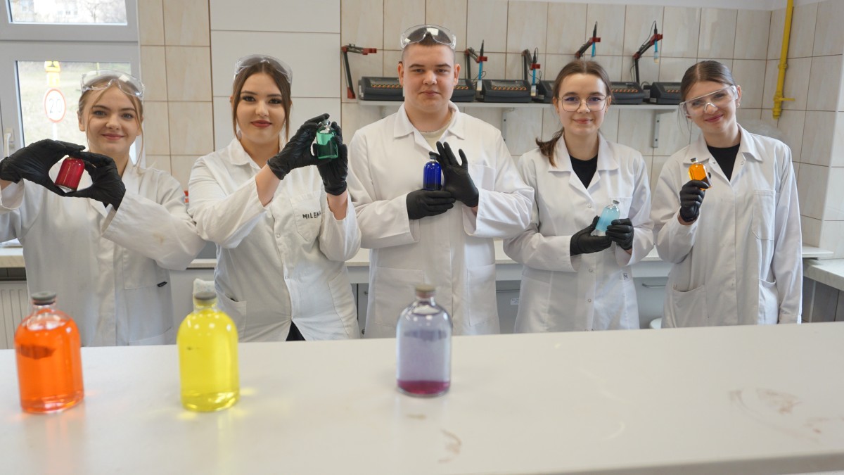 Uczniowie w fartuchach w laboratorium chemicznym