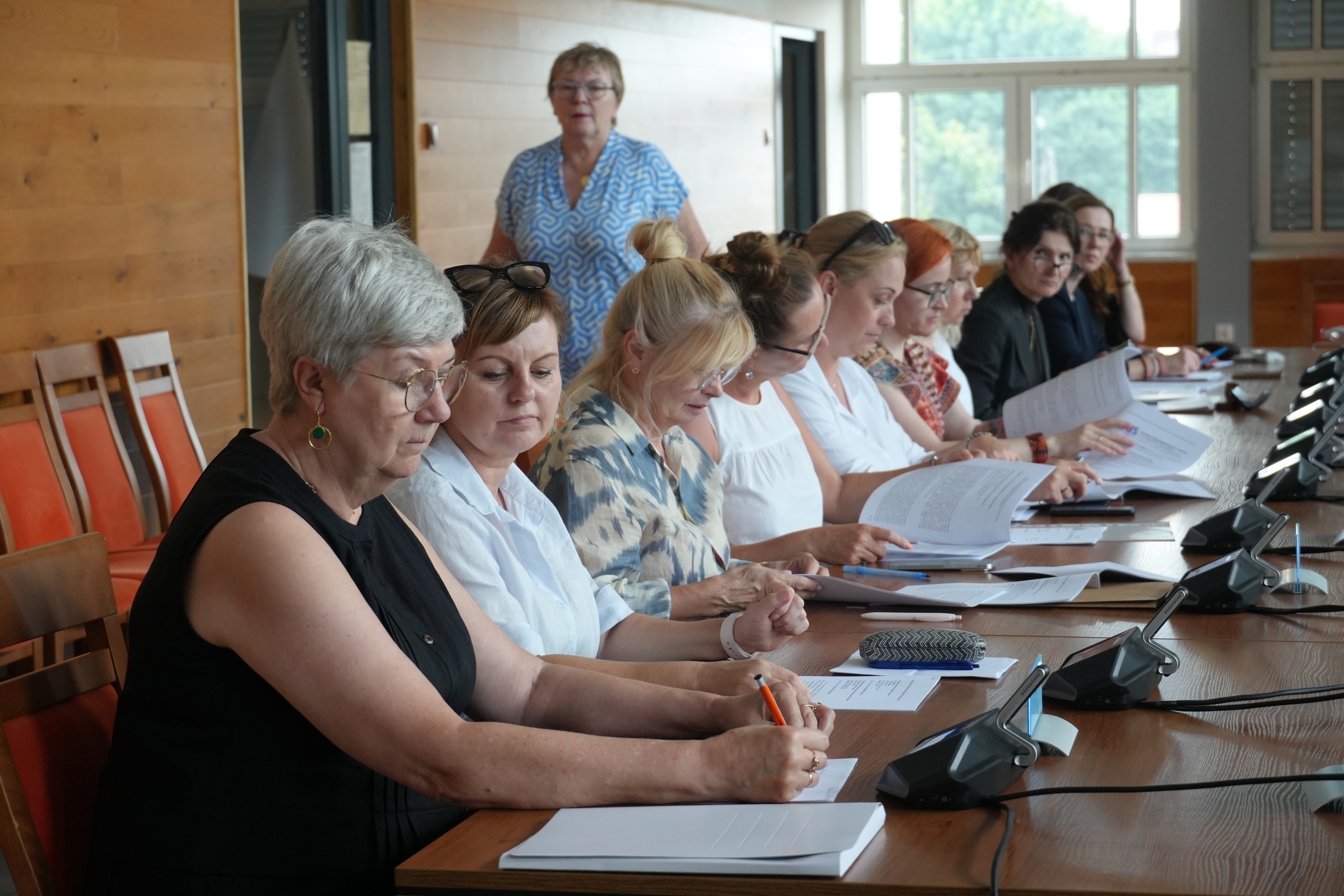 Uczestnicy spotkania siedzą przy stołach 
