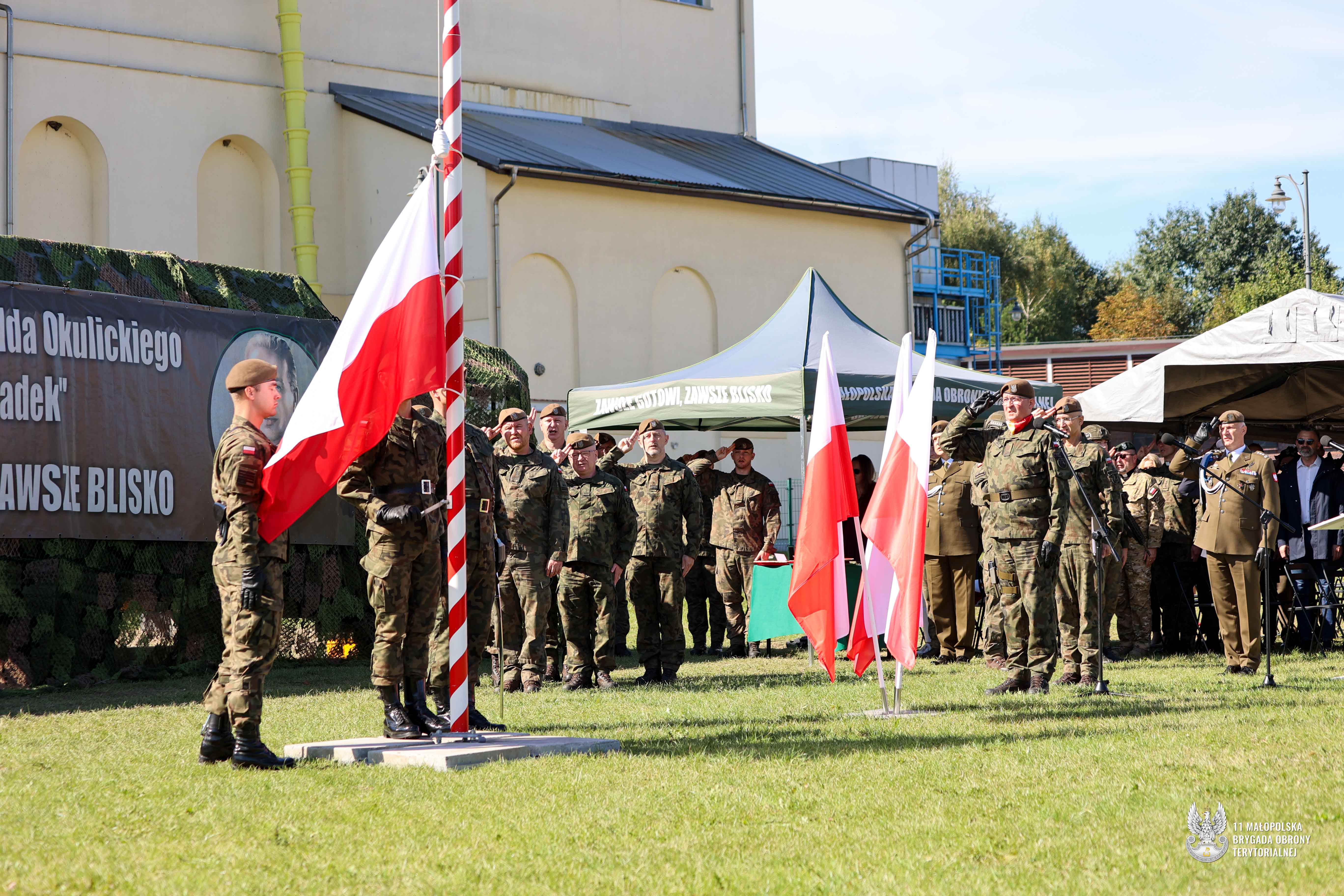 Poczet flagowy żołnieży wywiesza flage państwową na masz.