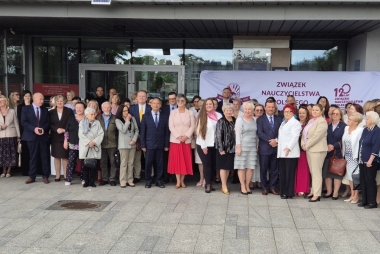 Uczestnicy jubileuszu stoją przed budynkiem chrzanowskiej biblioteki