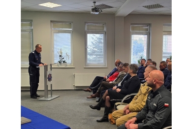 Zdjęcie kilunastu osób na sali konferencyjnej.