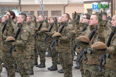 Mężczyźni w mundurach stoją na baczność 