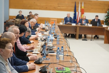 Radni powiatowi w sali narad podczas sesji. Przed nimi mikrofony