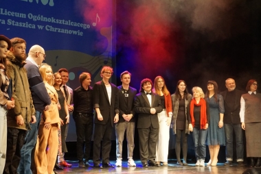Absolwenci na scenie pozują do zdjęcia, w sumie 17 osób 