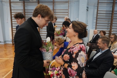Uczeń wręcza kwiaty nauczycielce 
