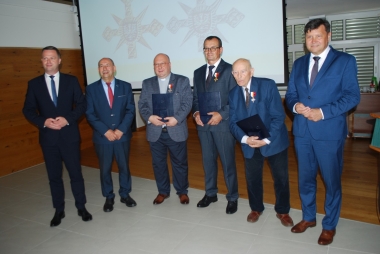 Sześciu mężczyzn pozujących do zdjęcia, wszyscy w garniturach 