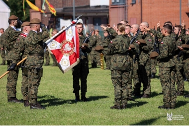 Zdjęcie kilkunastu żołnieży składających przysięgę przed sztandarem.
