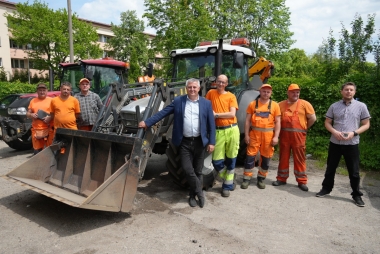 Dyrektor PZD i jego zastępca z częścią ekipy remontowej stoją przy dwóch ciągnikach