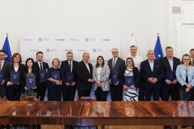 Kobiety i mężczyźni pozują do zdjęcia w urzędzie wojewódzkim w Krakowie